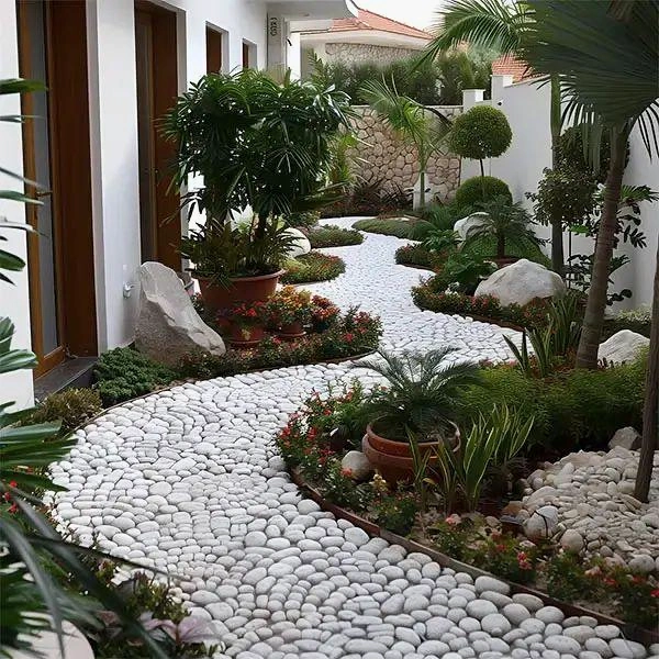 Curved white pebble path between planted beds.