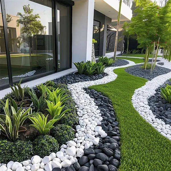 Curved lawn strip bordered by planting and contrasting pebbles.